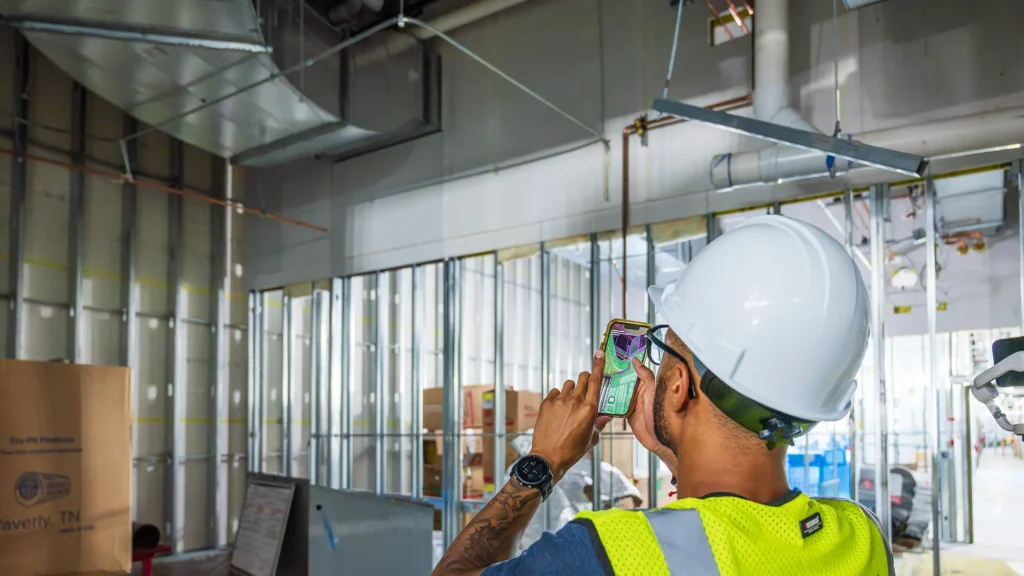 Employee using GAMMA AR on smartphone to see MEP on ceiling